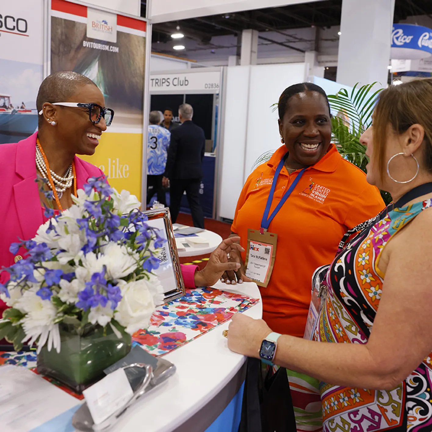 Group of three people networking on the showfloor at IMEX America
