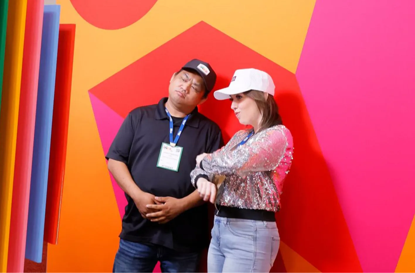 Two people standing in front of IMEX logo