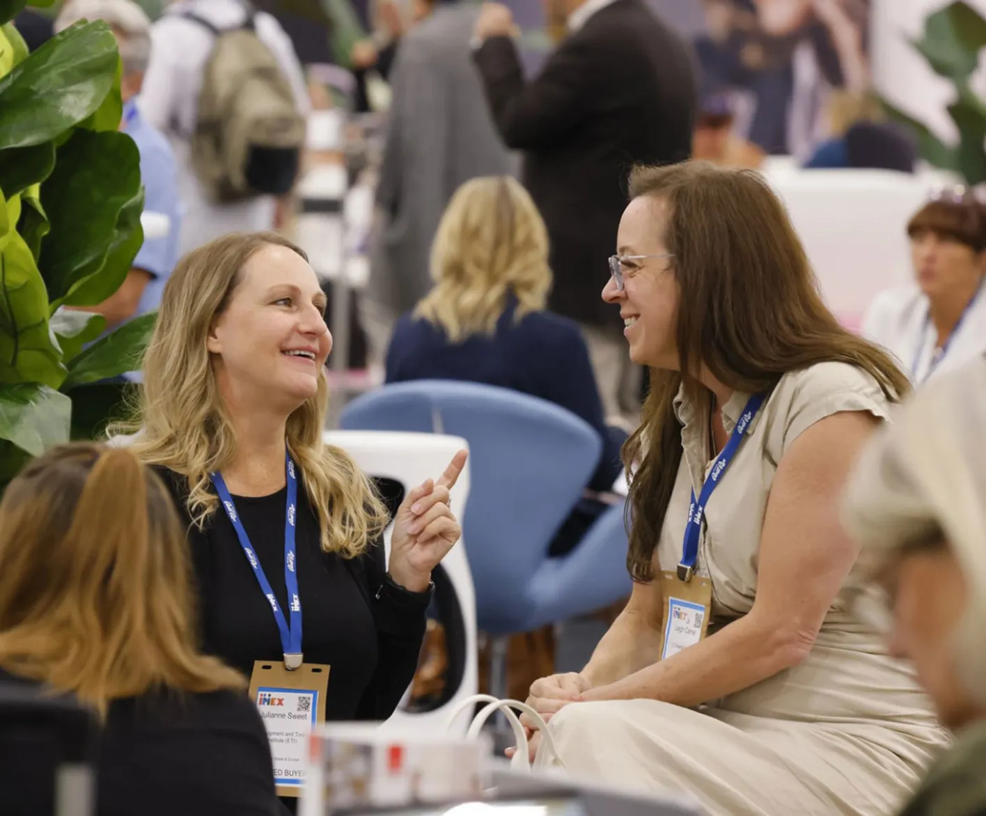 Smiling participants during a seated break at IMEX tradeshow.