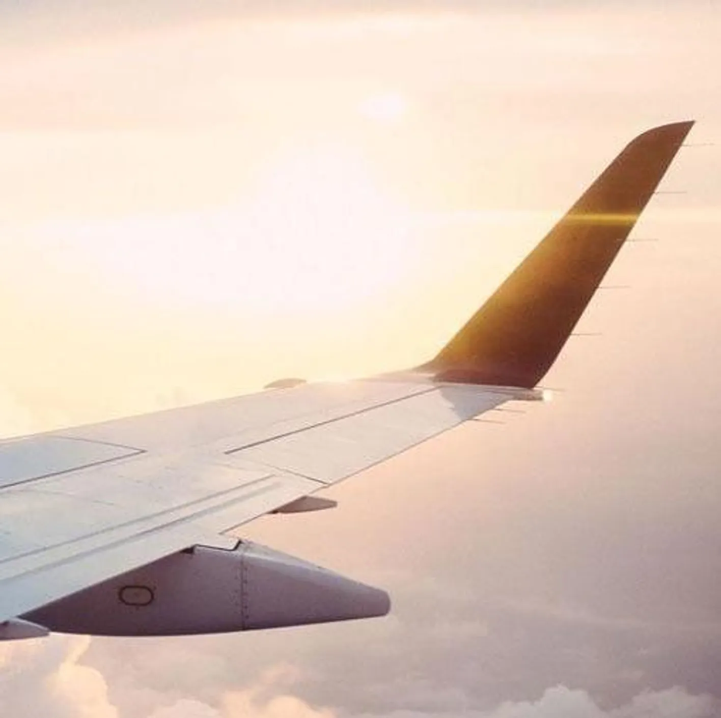 Airplane wing flying above the clouds