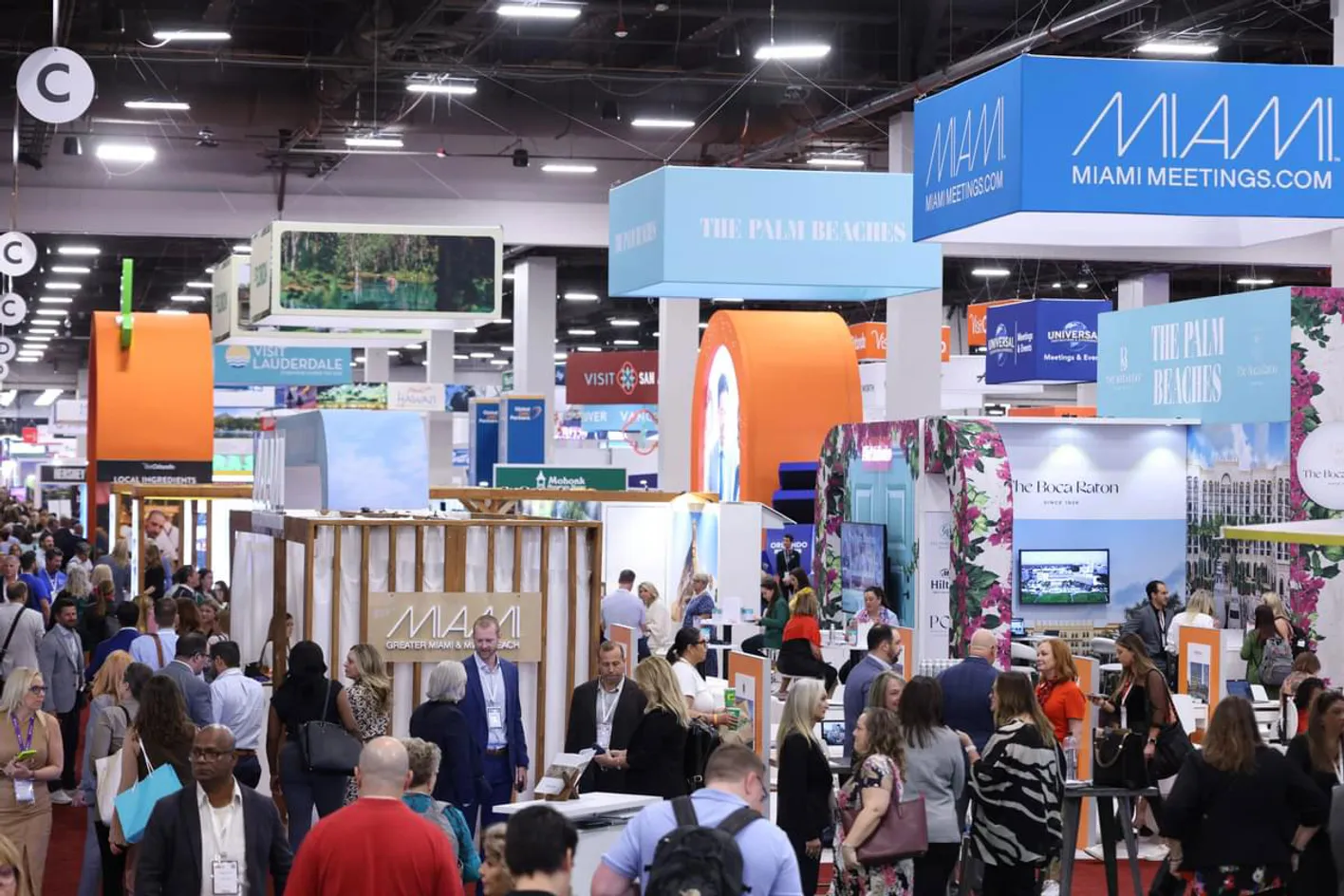 Large crowd of professionals engaging in conversations and exploring booths on the showfloor