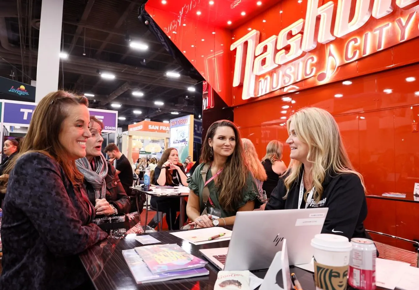 Female professionals gathered around a booth at IMEX America