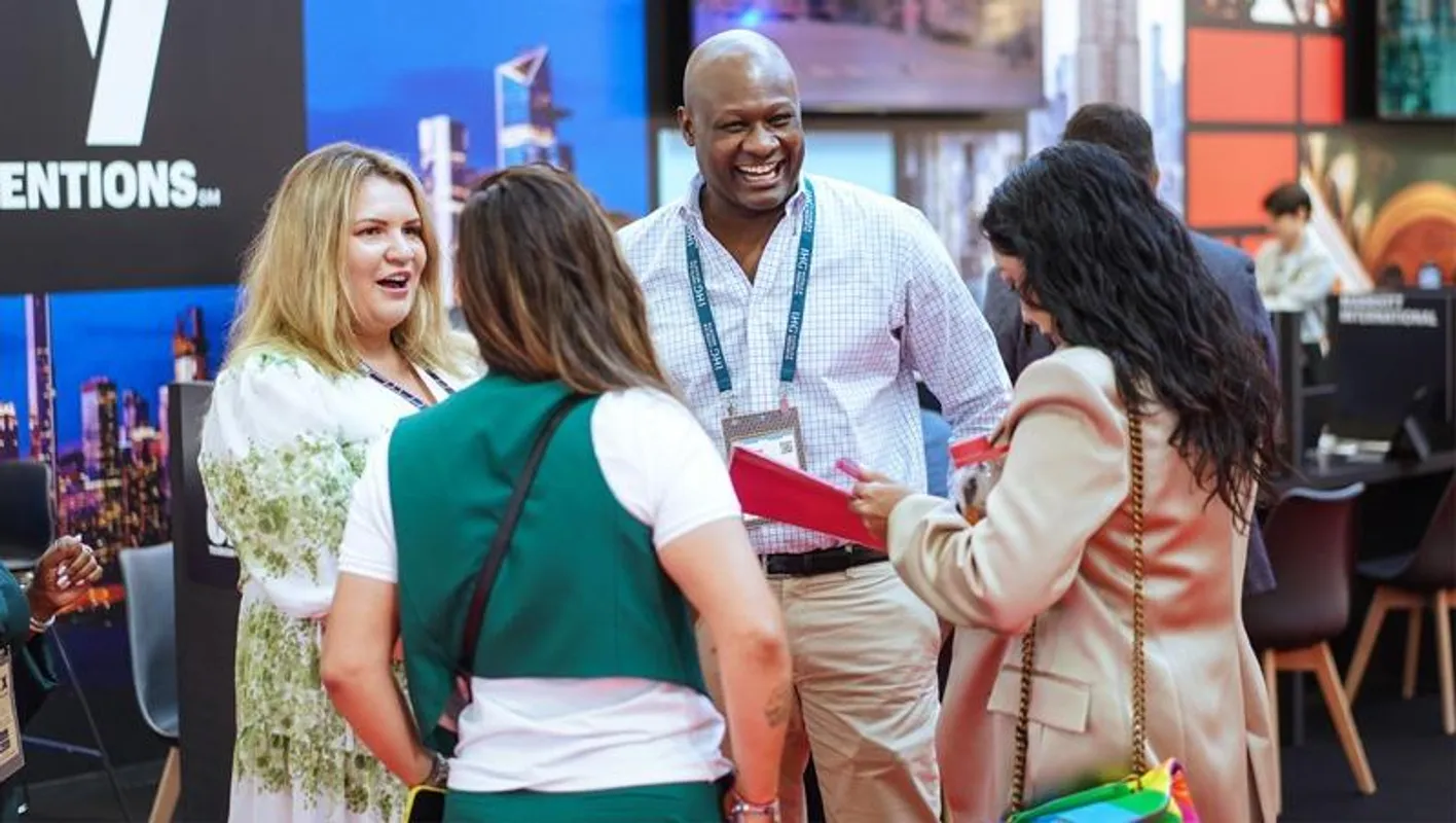 A group of attendee laughing and smiling on at IMEX. Two of them have their back to the camera.