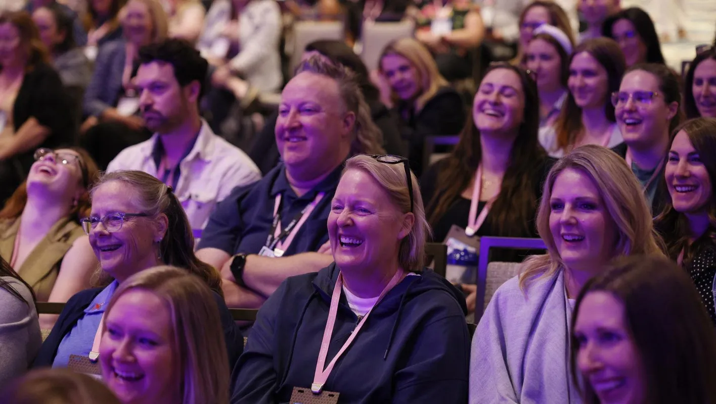 Seated crowd smiling at inspiring talk for association planners