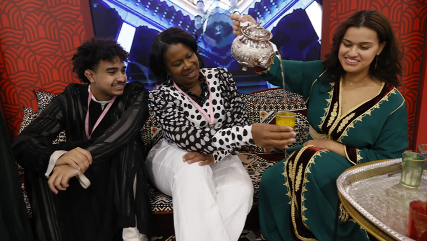 exhibitors and participants share a traditional tea at a booth in the Mandalay exhibition hall