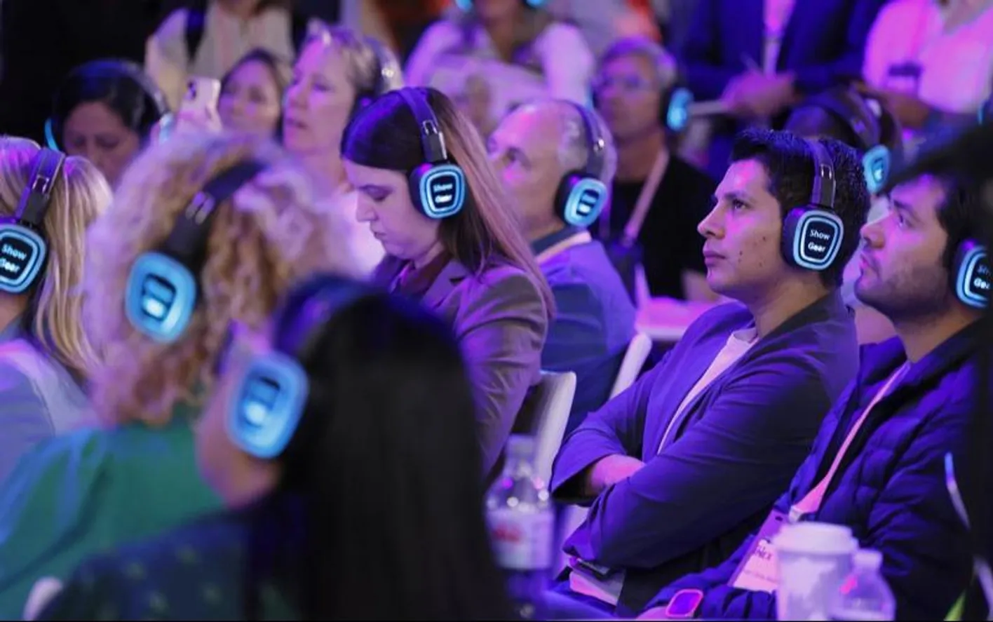Audience members with glowing audio headphones at an education session 