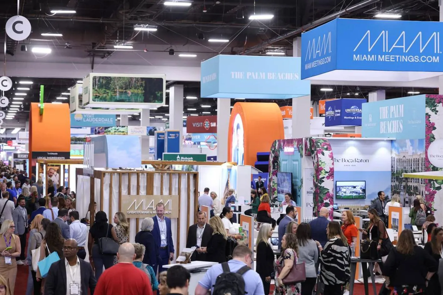 Large crowd of professionals engaging in conversations and exploring booths on the showfloor