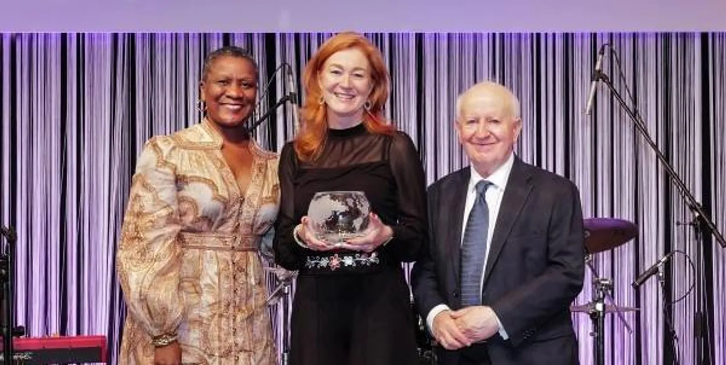 Award winner holding her award alongside Ray Bloom, IMEX Chairman.