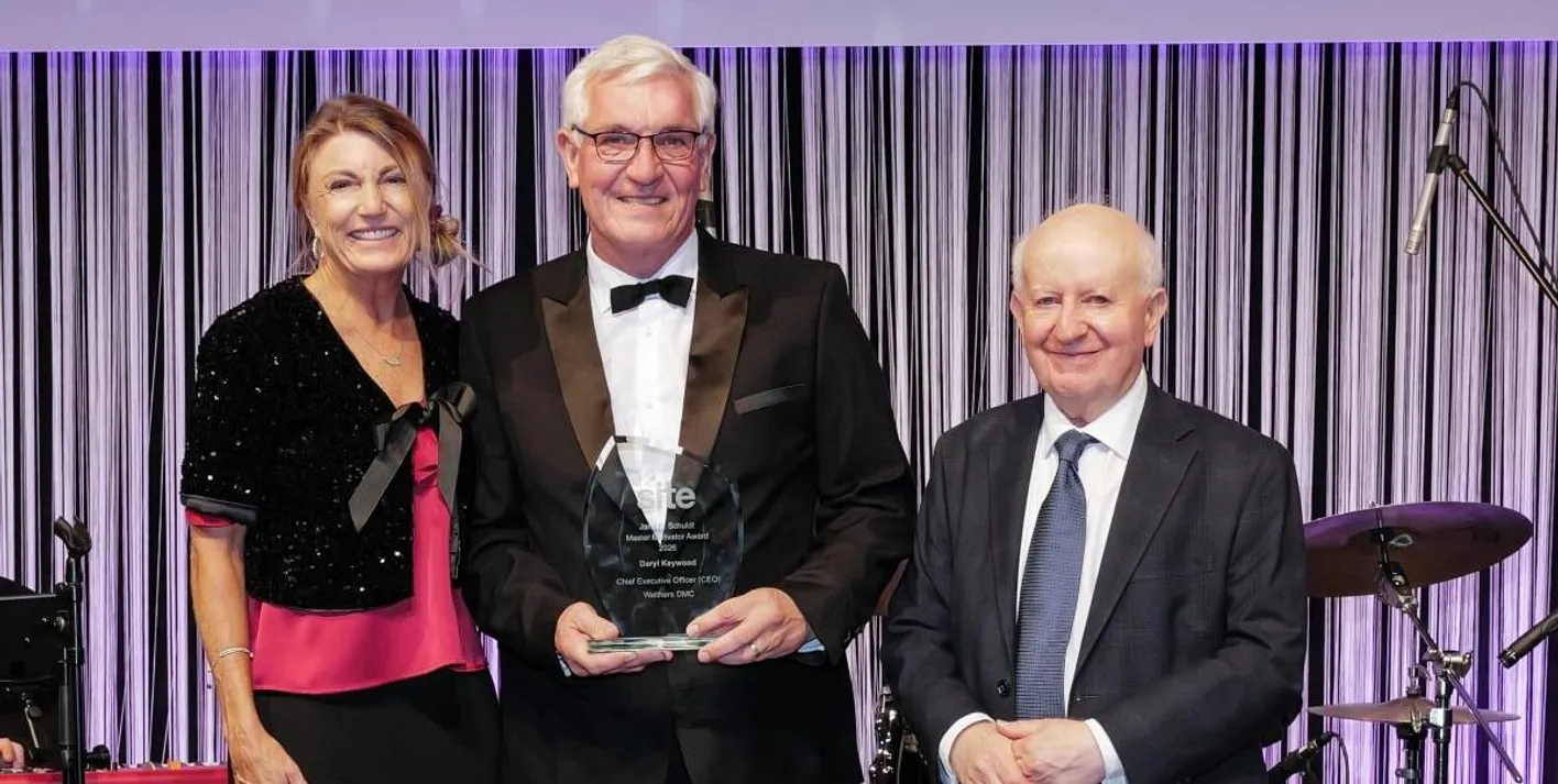 Two award winners stand with IMEX Chairman, Ray Bloom, collecting a white award
