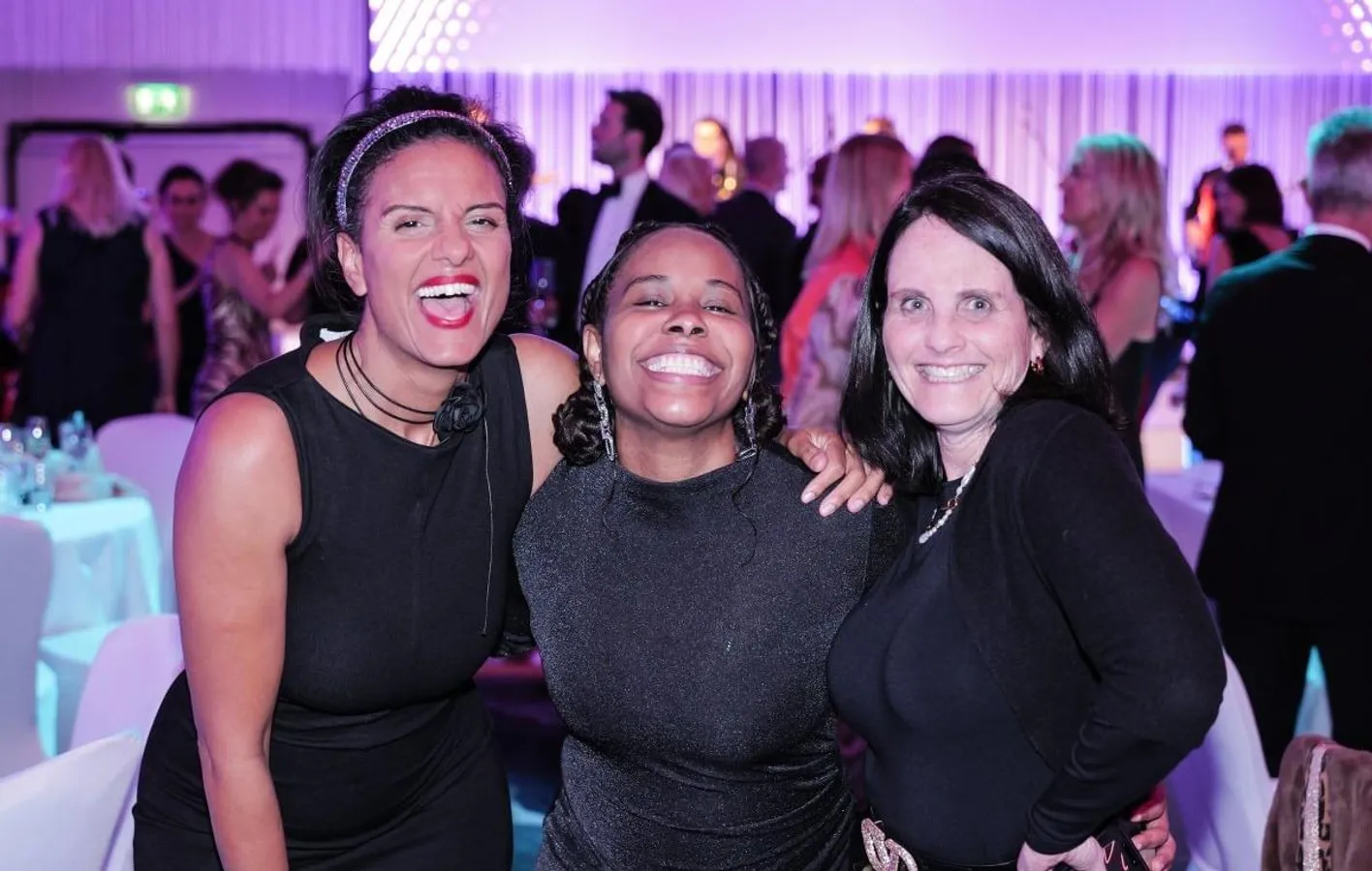 Three gala dinner attendees smiling at the camera