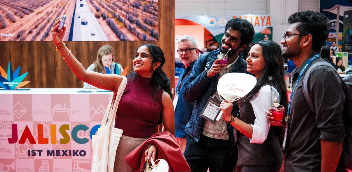 Attendees taking a selfie in front of a booth with a Japan fan