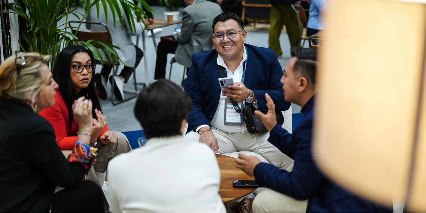 Attendees in conversation while sitting on some comfortable chairs around a table