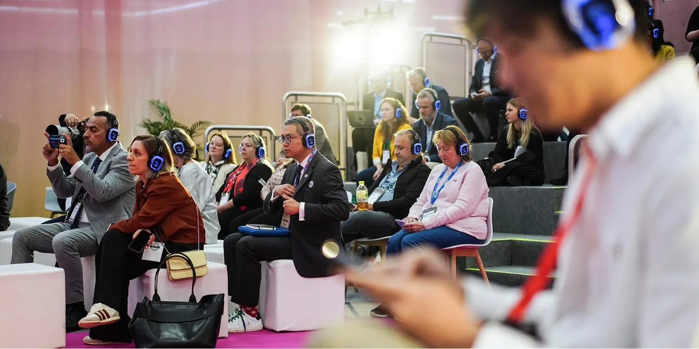 Teilnehmer auf gestuften Sitzreihen beobachten einen Redner während der IMEX-Schulungen.