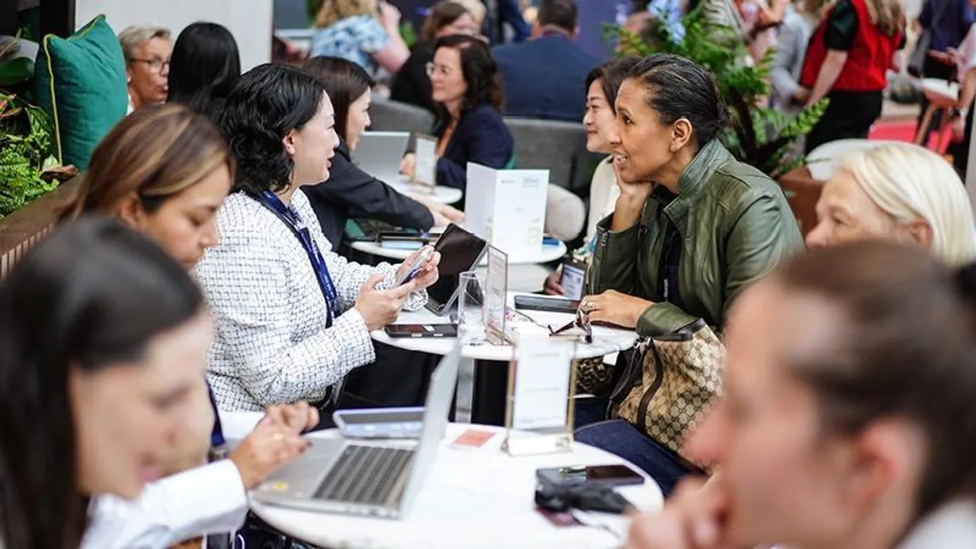 A row of tables with seated exhibitors meeting buyers