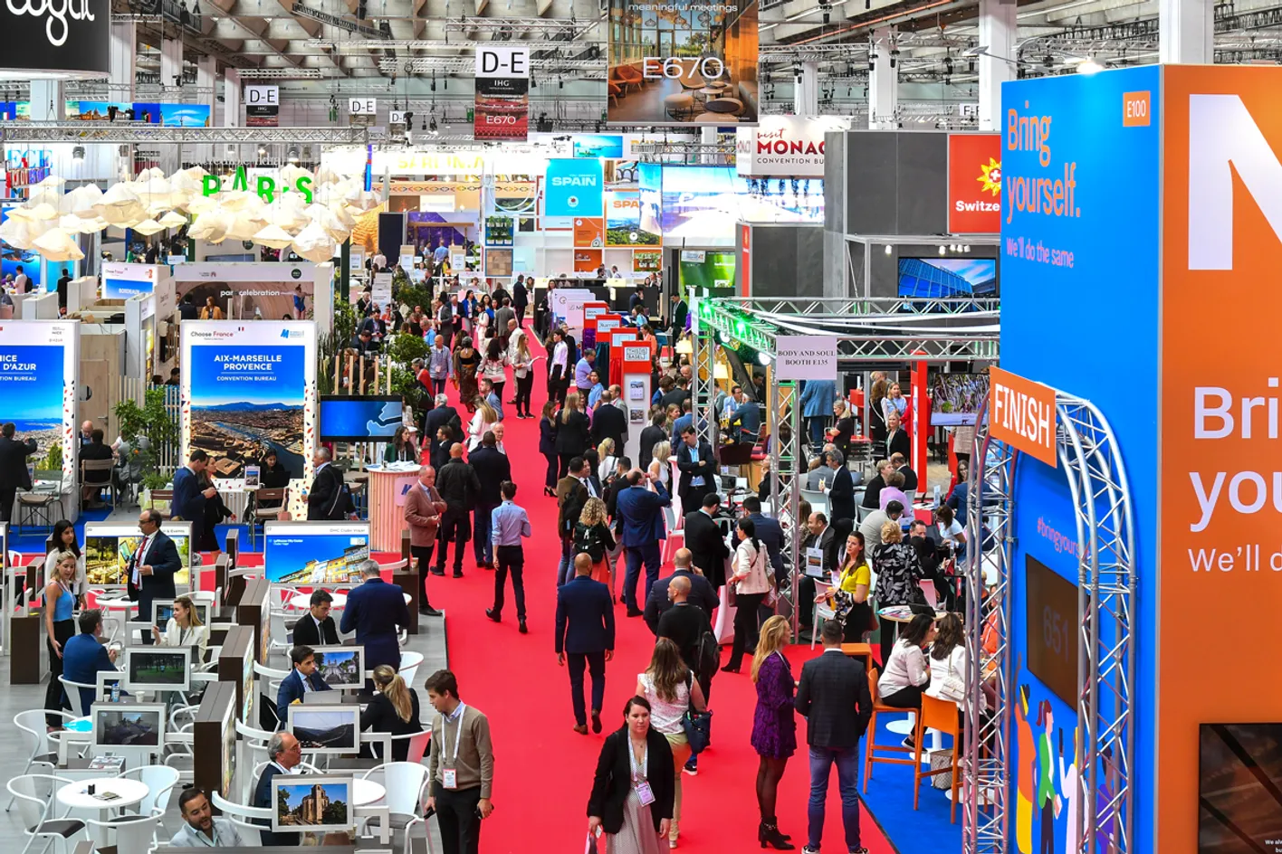 A high up view of IMEX Frankfurt's show floor. There's a large group of attendees on a red carpet