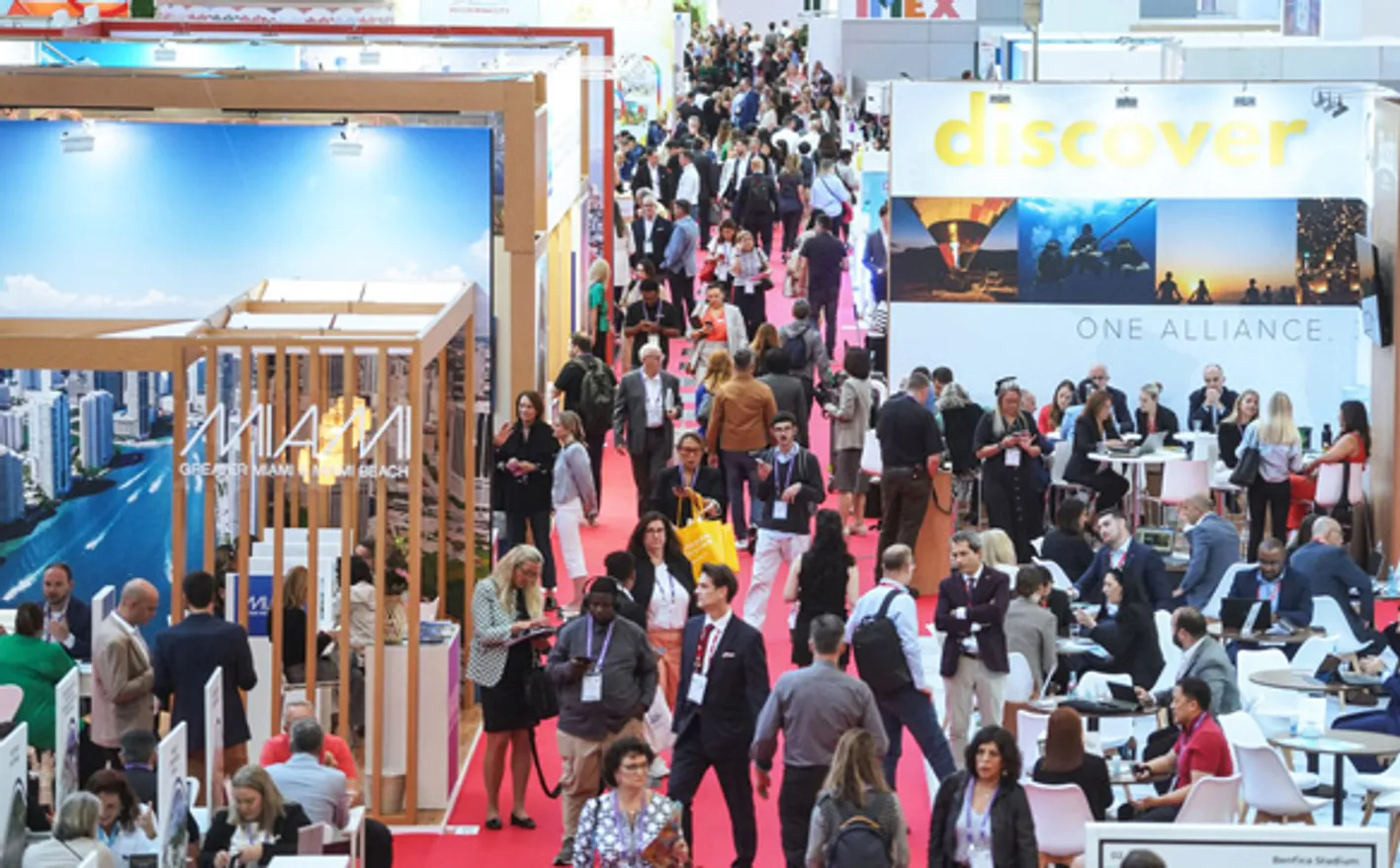 A busy red carpeted aisle of IMEX Frankfurt's show floor.