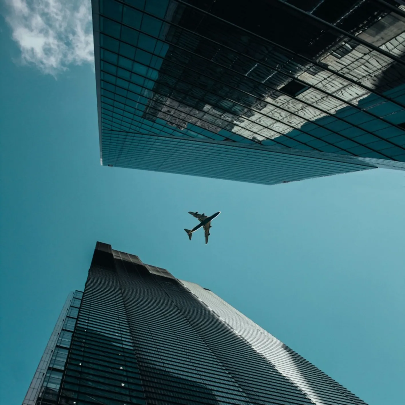 Plane flying high above two city buildings