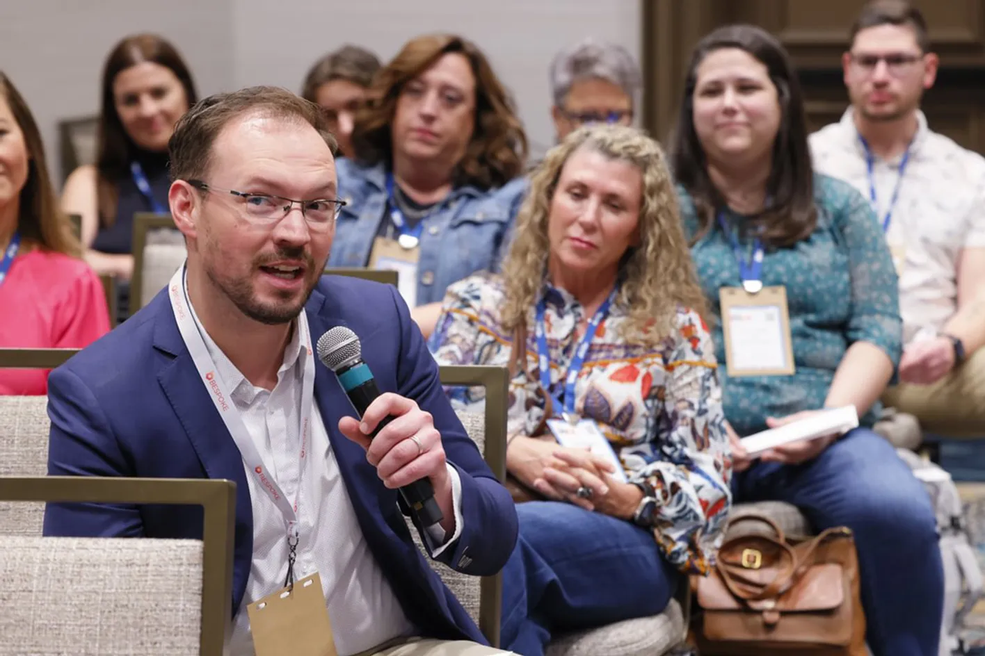 Audience member participating in a corporate education session with a microphone in hand