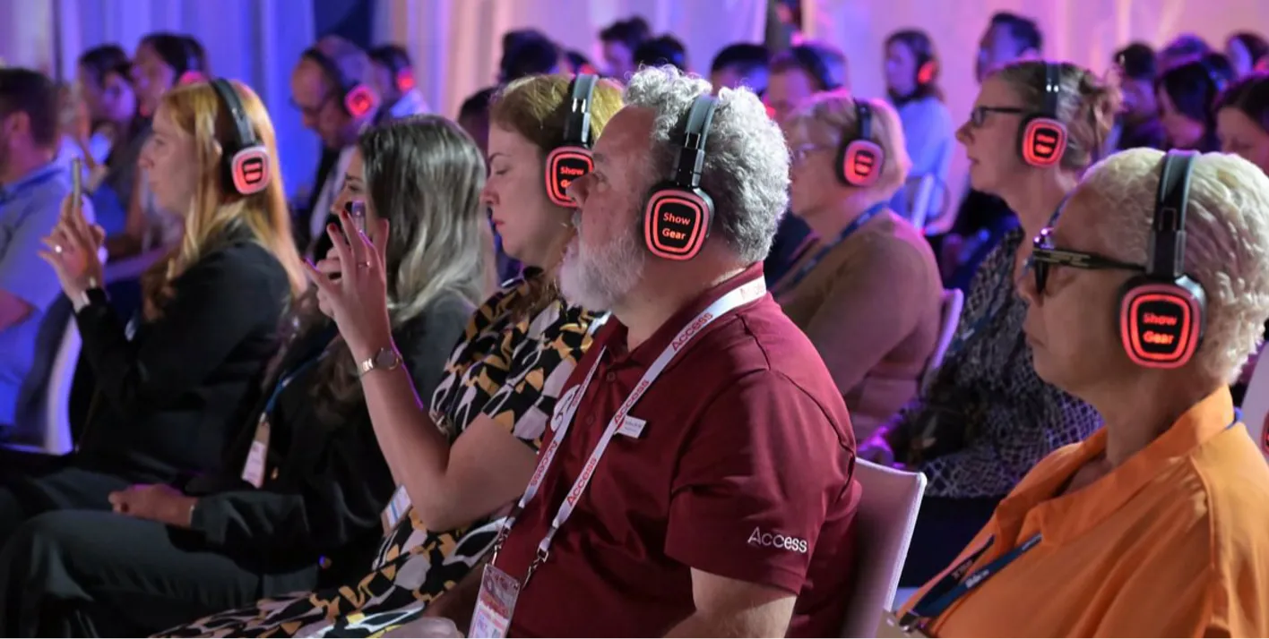 Audience members with glowing audio headphones at an education session 