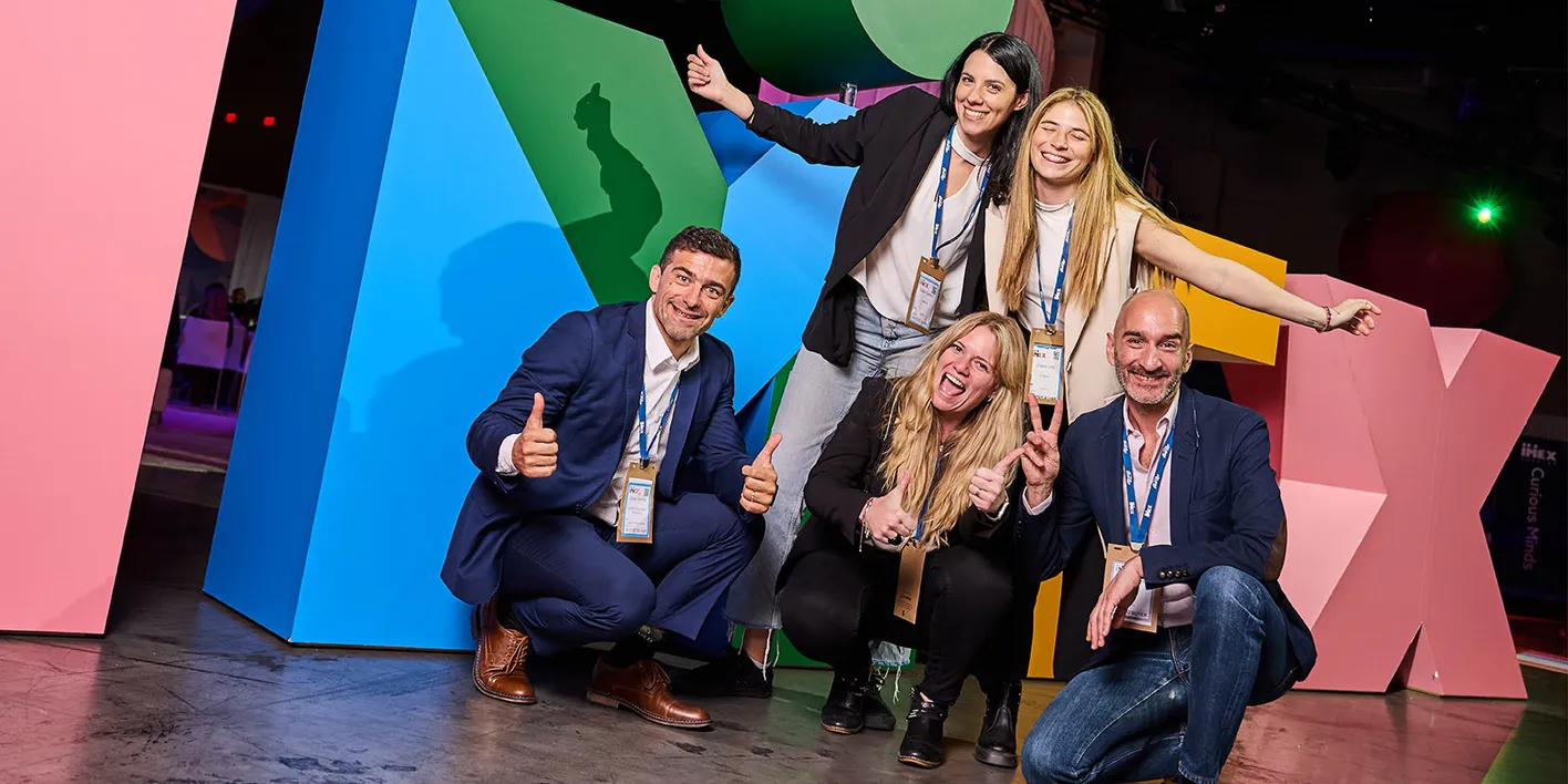 Group of event professionals in front of the IMEX sign in the inspiration hub