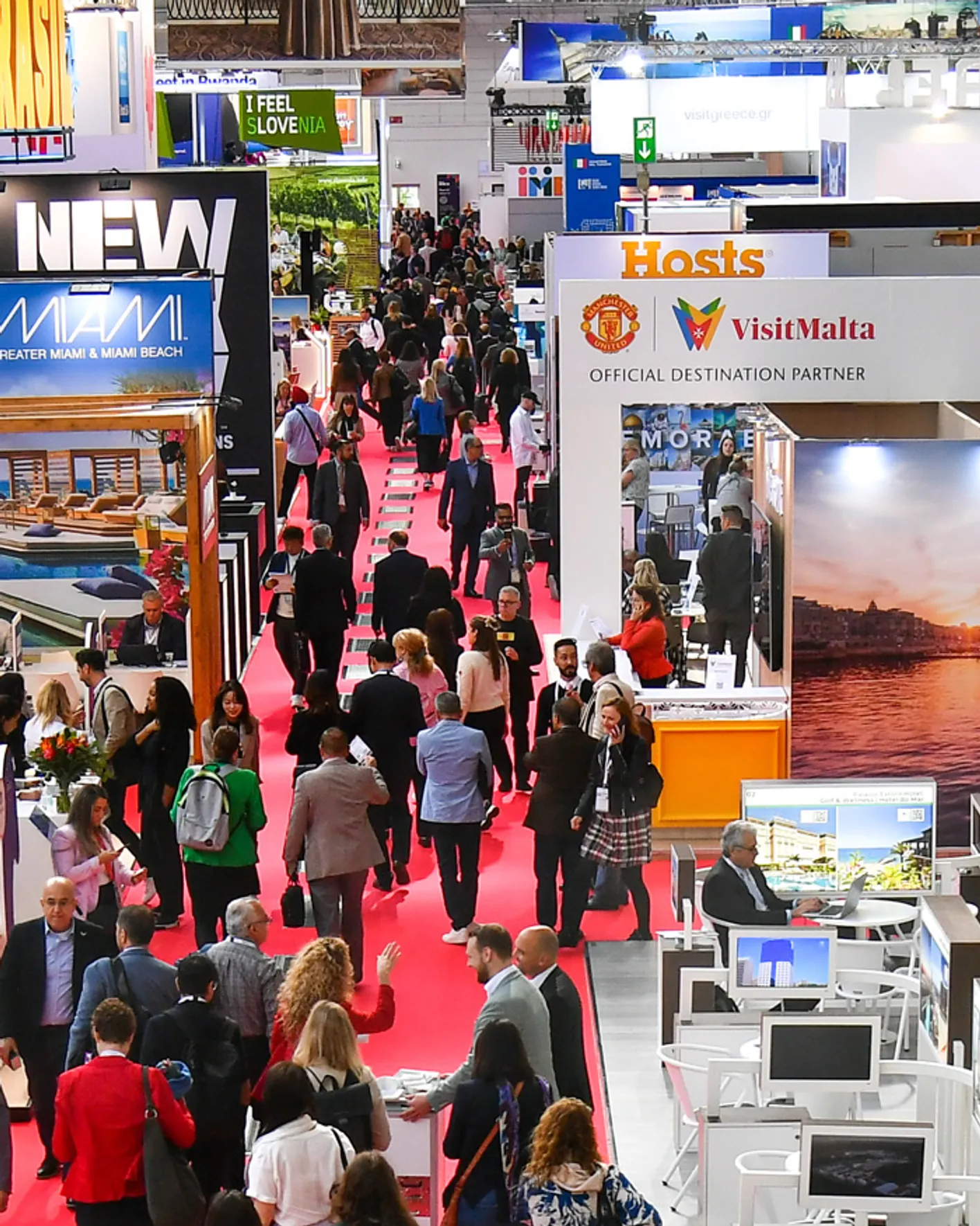 A crowd of people on the red carpet aisle of IMEX Frankfurt's show floor.