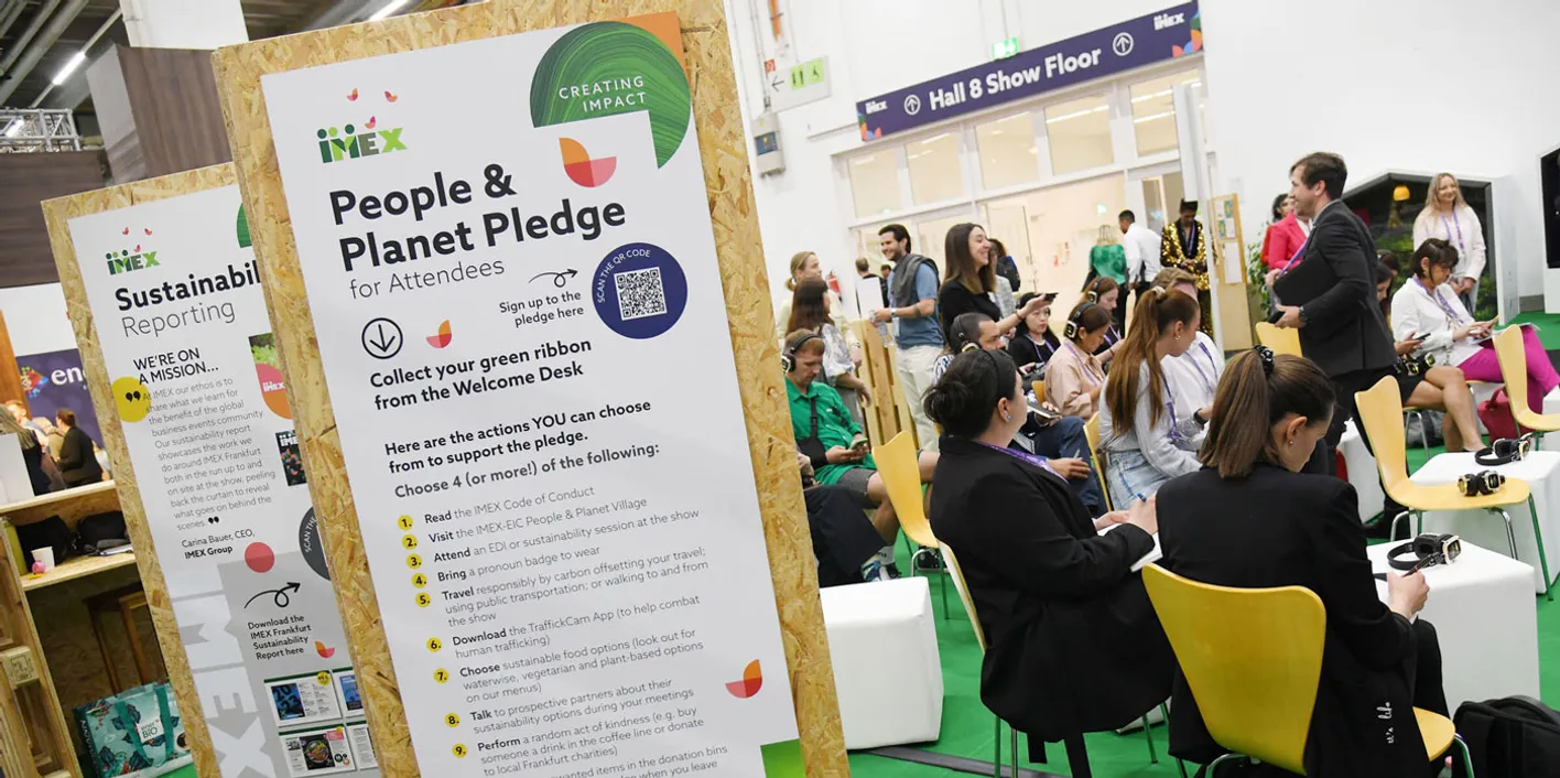 Attendees at IMEX Frankfurt sat near posters about the People and Planet Pledge and sustainability