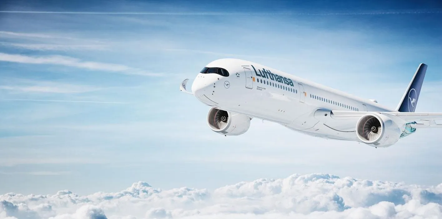 An image of a white Lufthansa plane in flight above a sea of clouds