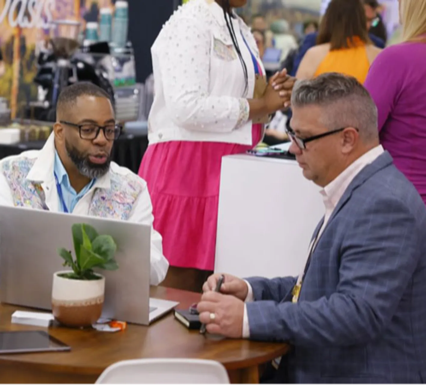 Two meetings professionals looking at a laptop while sitting down