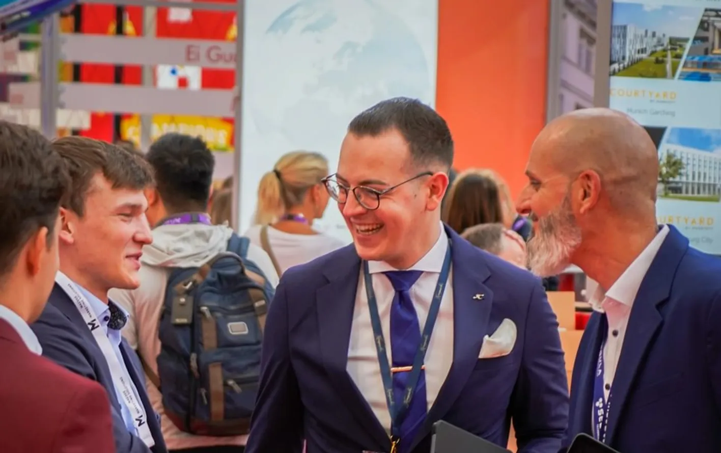 Professionals engaged in conversation at IMEX booth