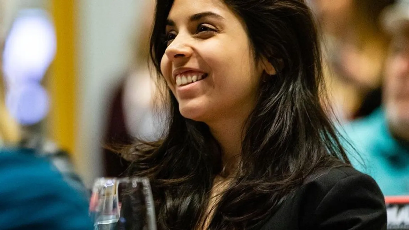 A woman is smiling. She attends a masterclass at the Vinexpo Academy.
