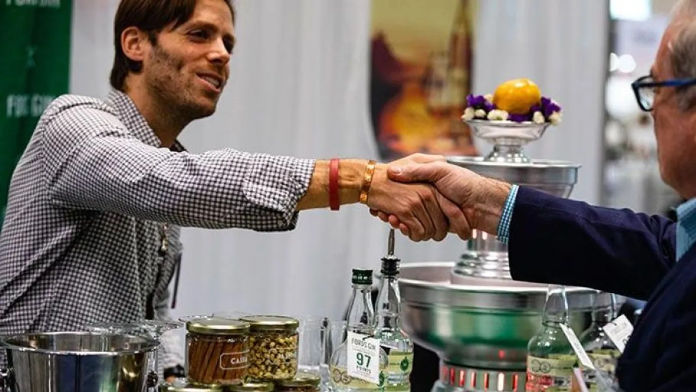 Men doing an handshake. One is a visitor, the other an exhibitor at Vinexpo Academy.