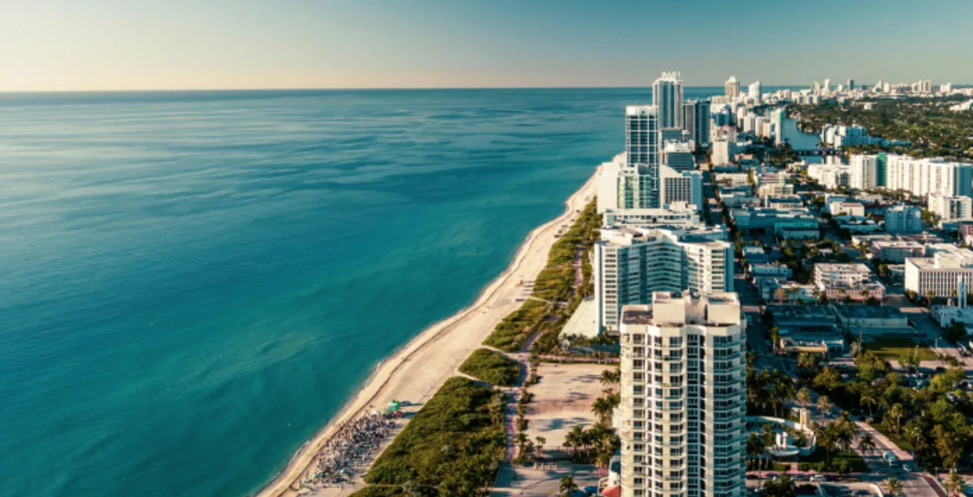 View from the sky of a beach in Miami on the left and on the right building.
