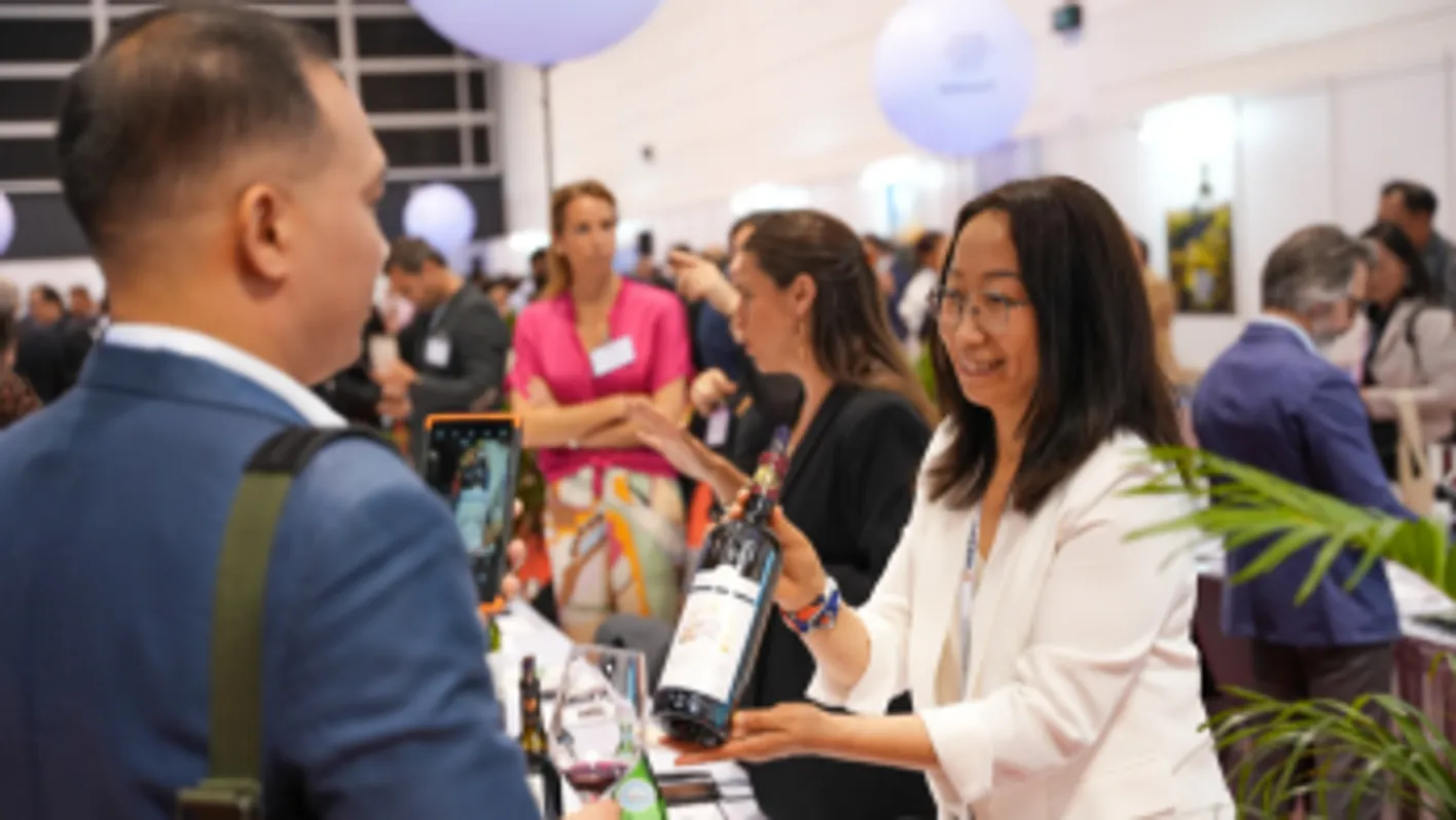 Visitors exploring exhibitor booths and engaging in conversation at Vinexpo Asia