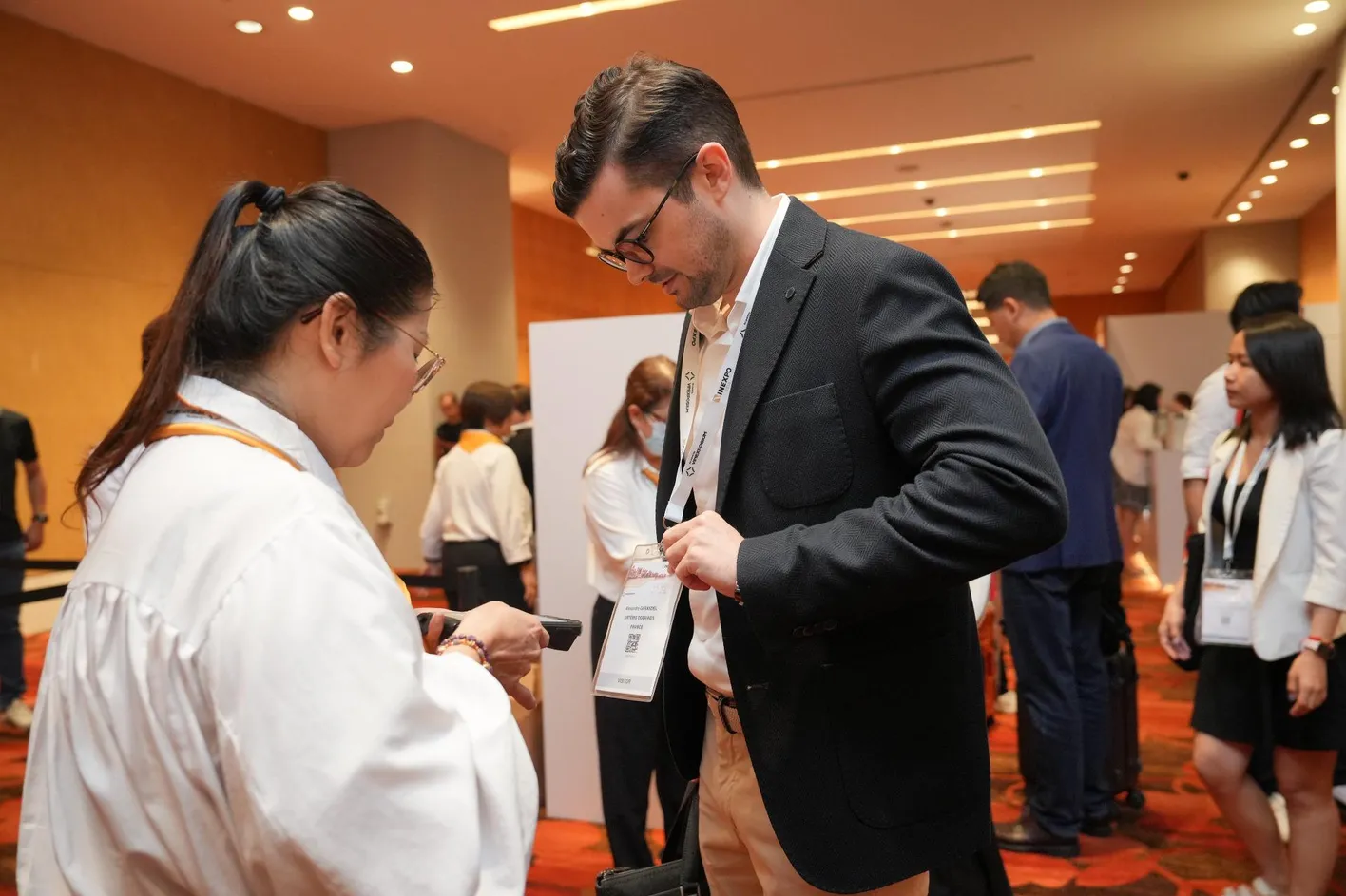 Exhibitor scanning a visitor badge using a mobile device at Vinexpo Asia
