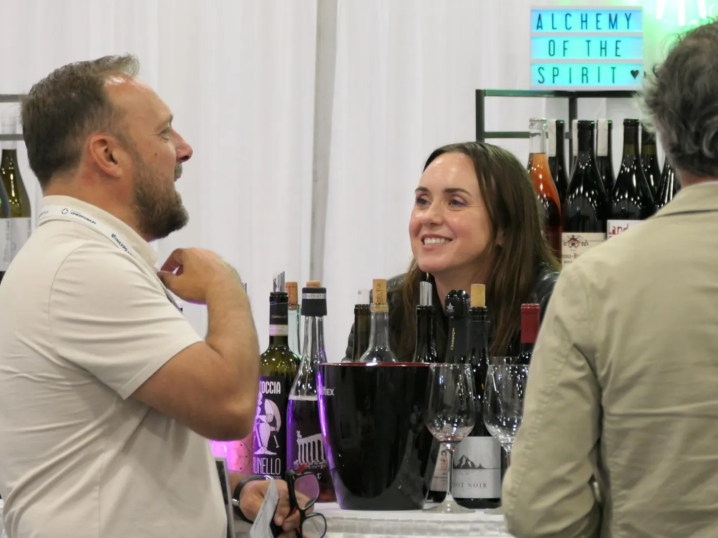 People, exhibitors and visitors are discussing and laughing.