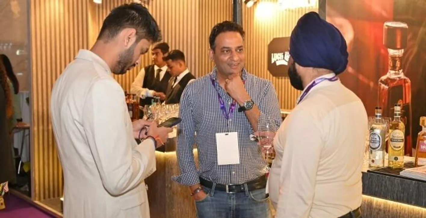 Three men are discussing during Vinexpo India, an exhibition between wine professionnals.