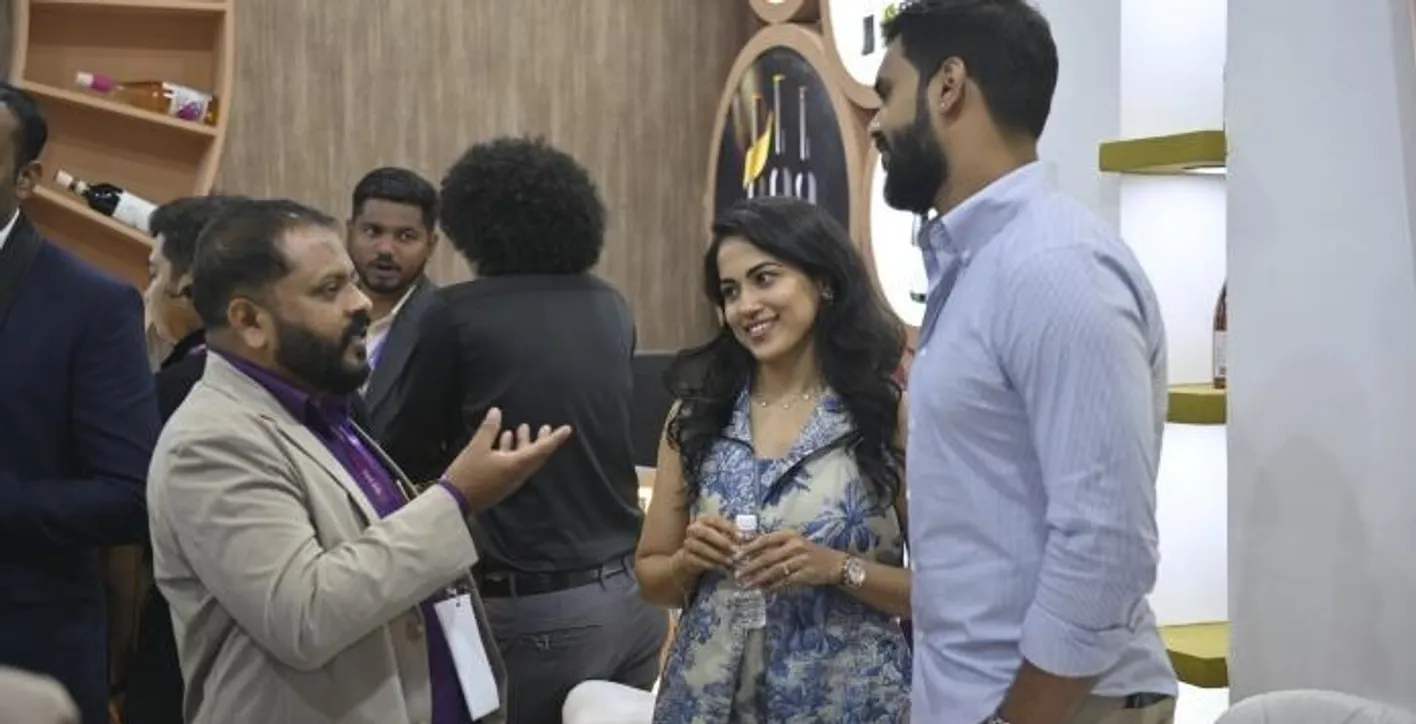 Two men and a woman are chatting during Vinexpo India.