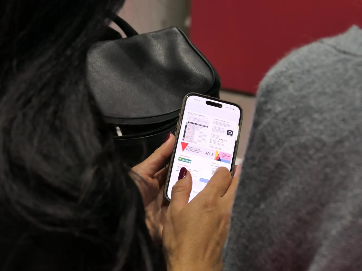 A woman holding her phone and searching for a certain file.