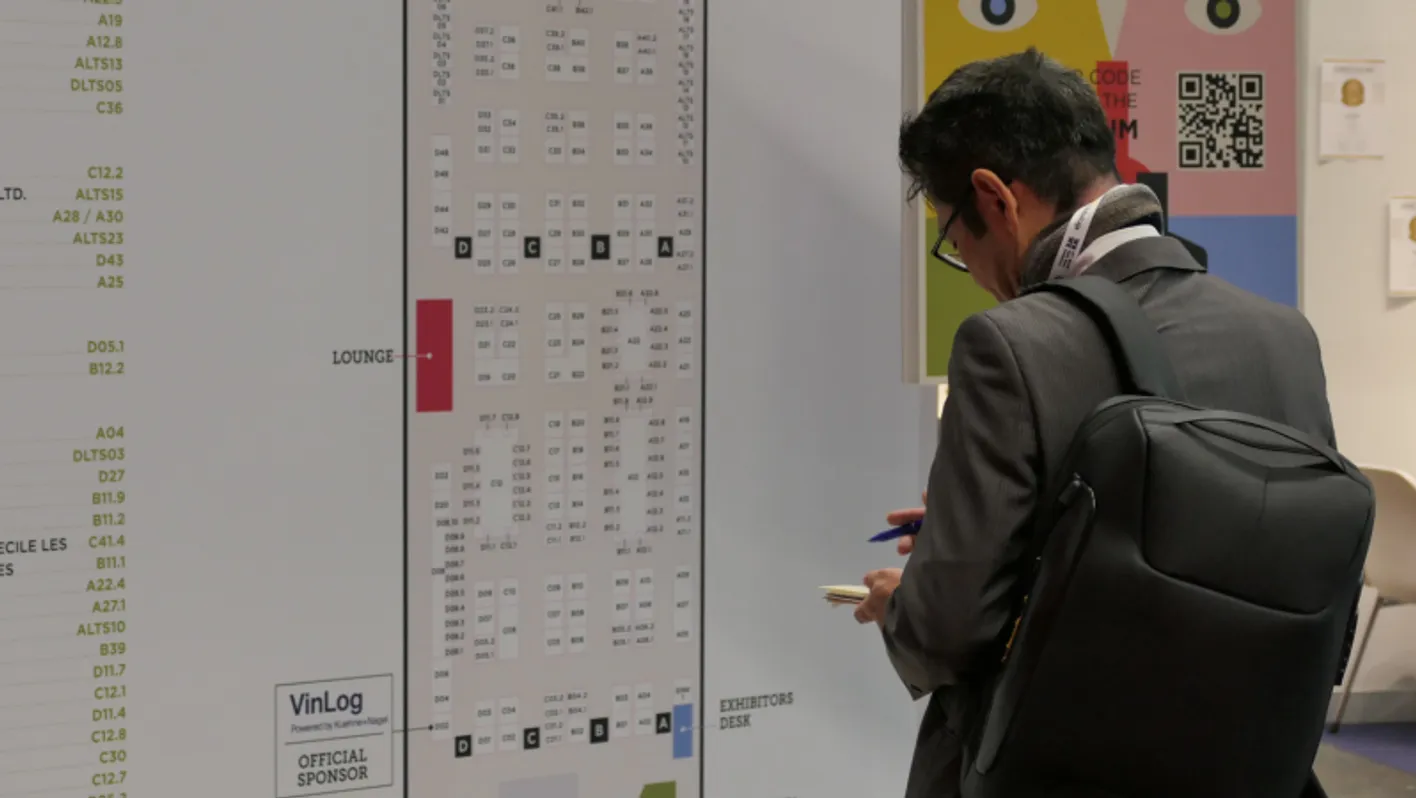 A man who is standing in front of the giant orientation map of WBWE exhibition.