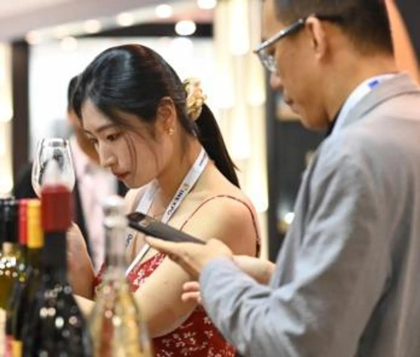 Trade visitor browsing exhibitor materials at Vinexpo Asia