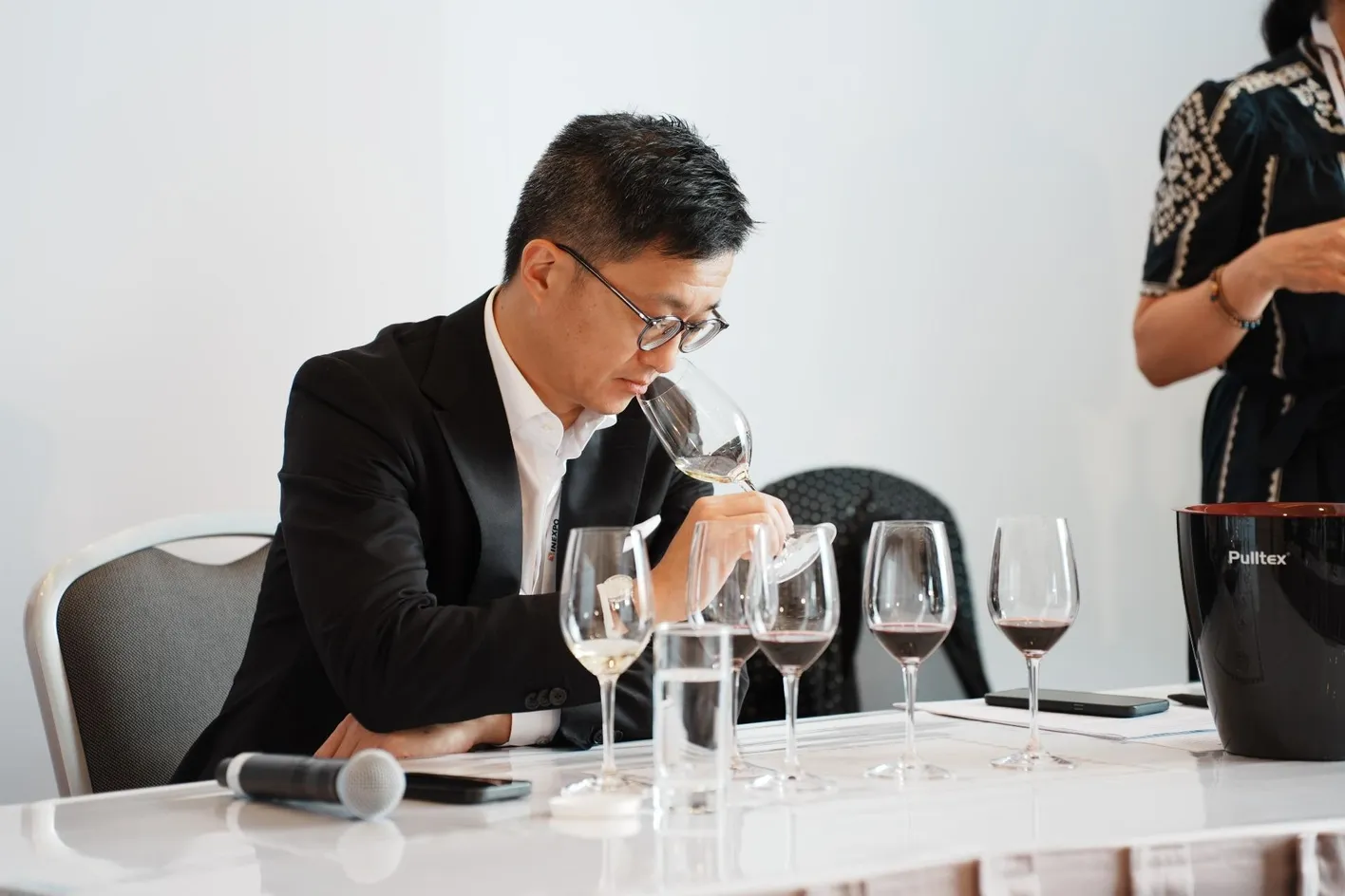 Close-up of red wine being poured into a glass during a tasting session
