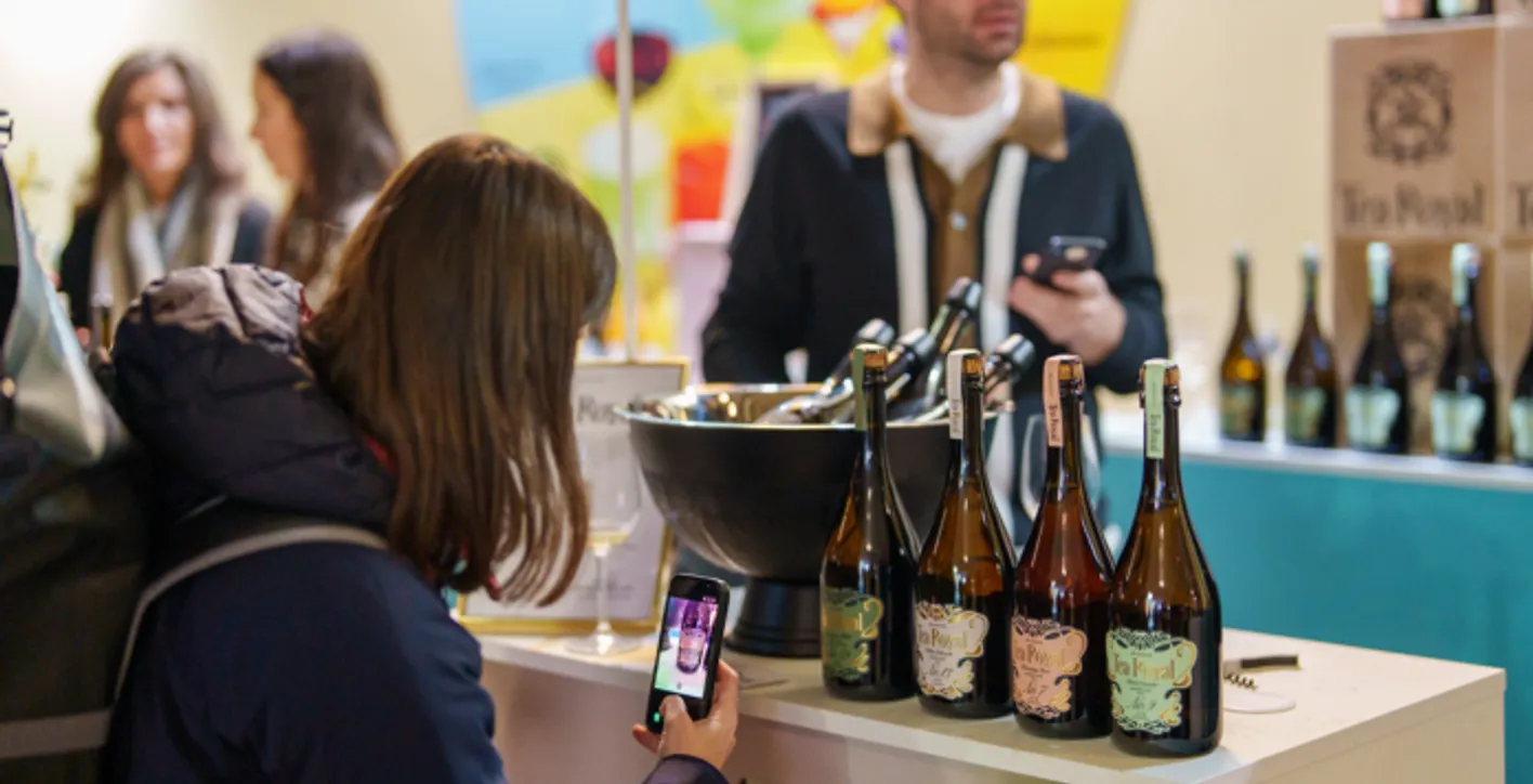 Lady taking a picture of a bottle of no-alcohol wine