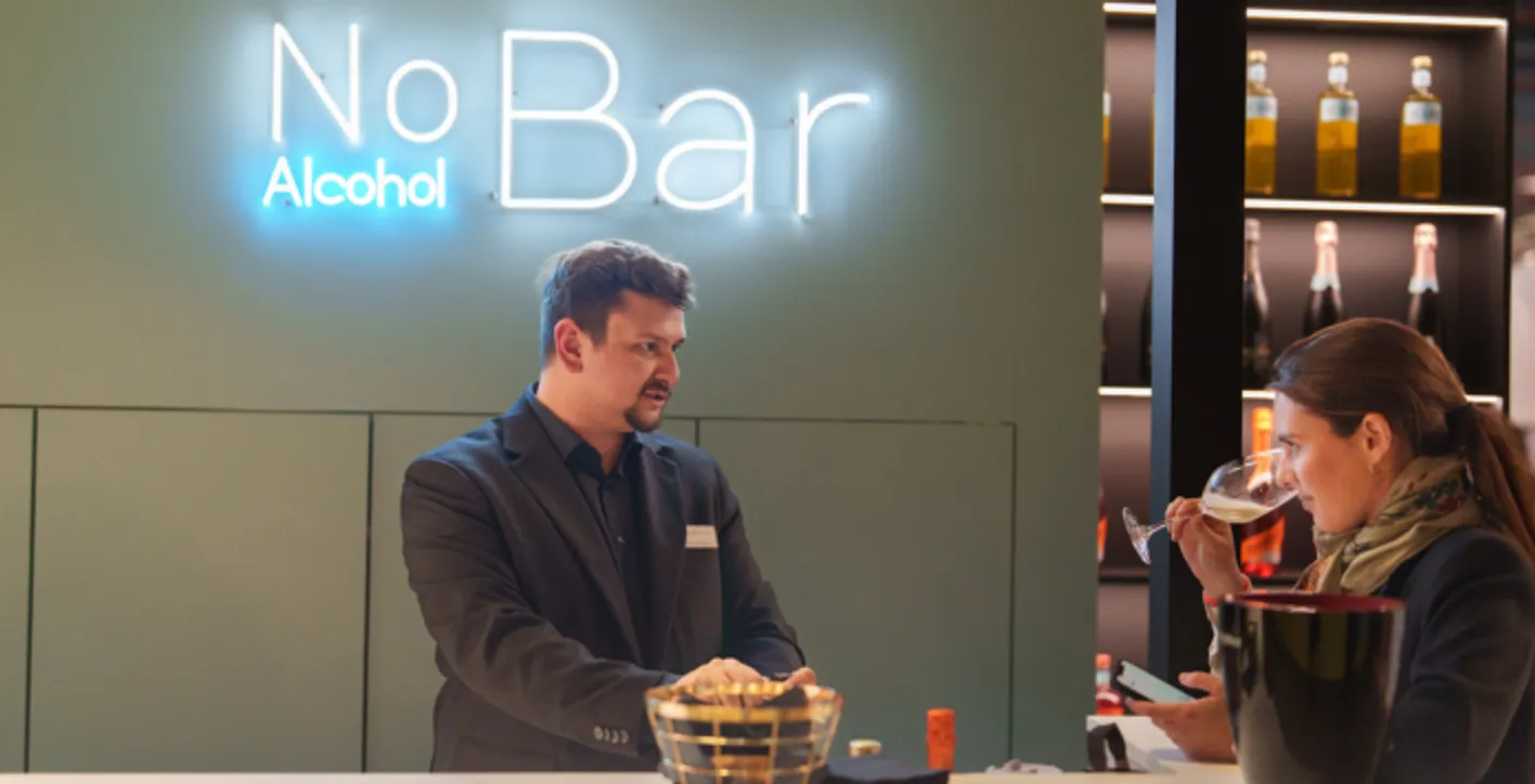 Gentleman presenting his alcohol free wine product to a lady