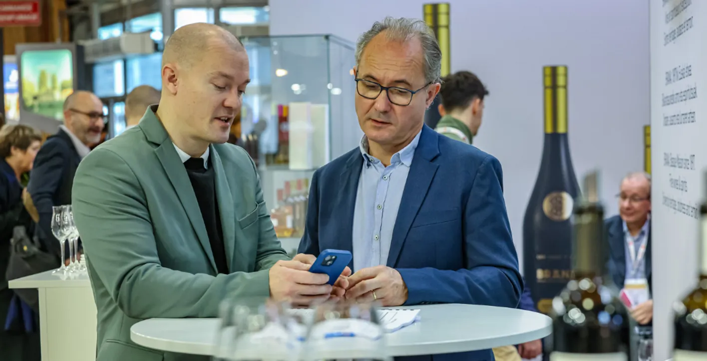 two men watching a smartphone to book a meeting