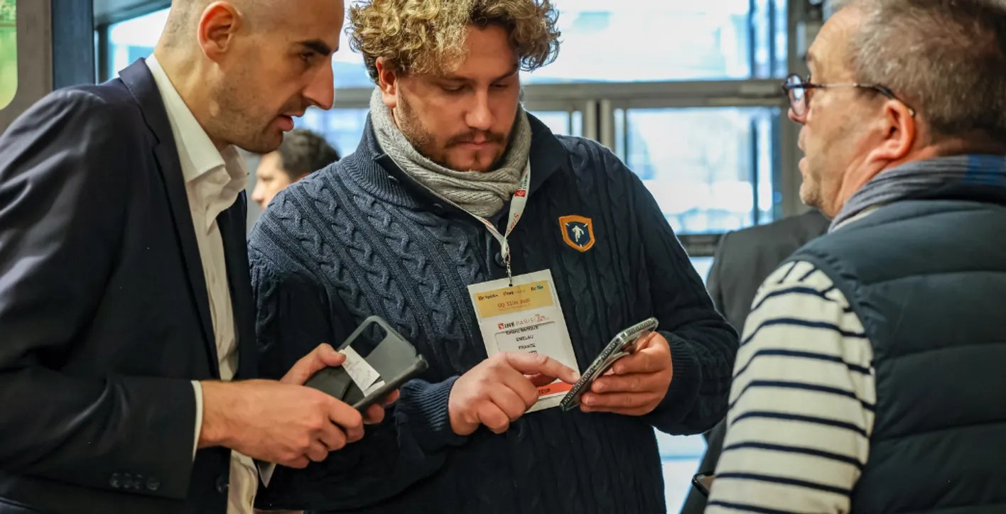 3 men talking and checking smartphone