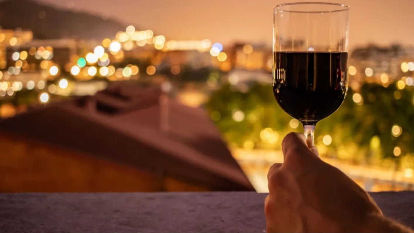 glass of wine in front of a night city view