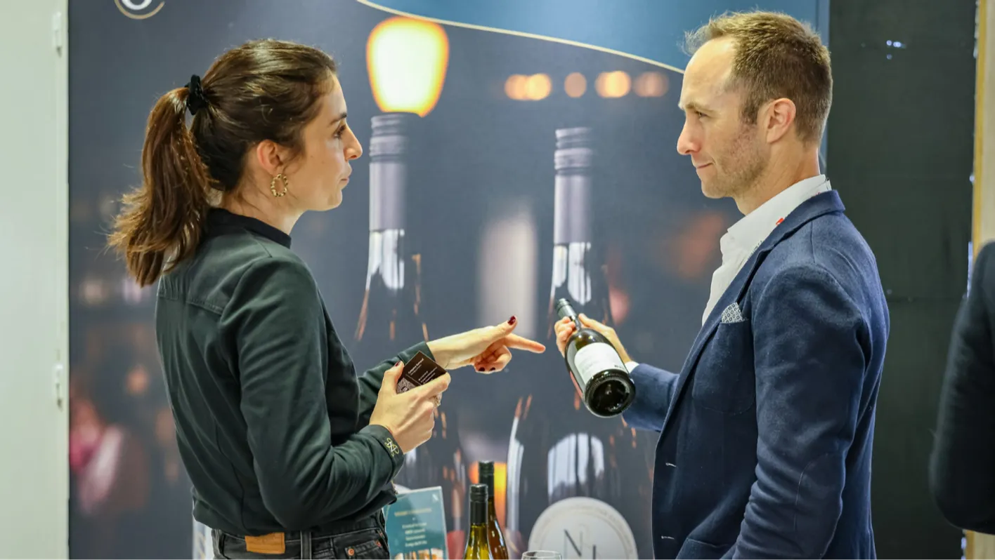 man and woman talking about wine at the trade show